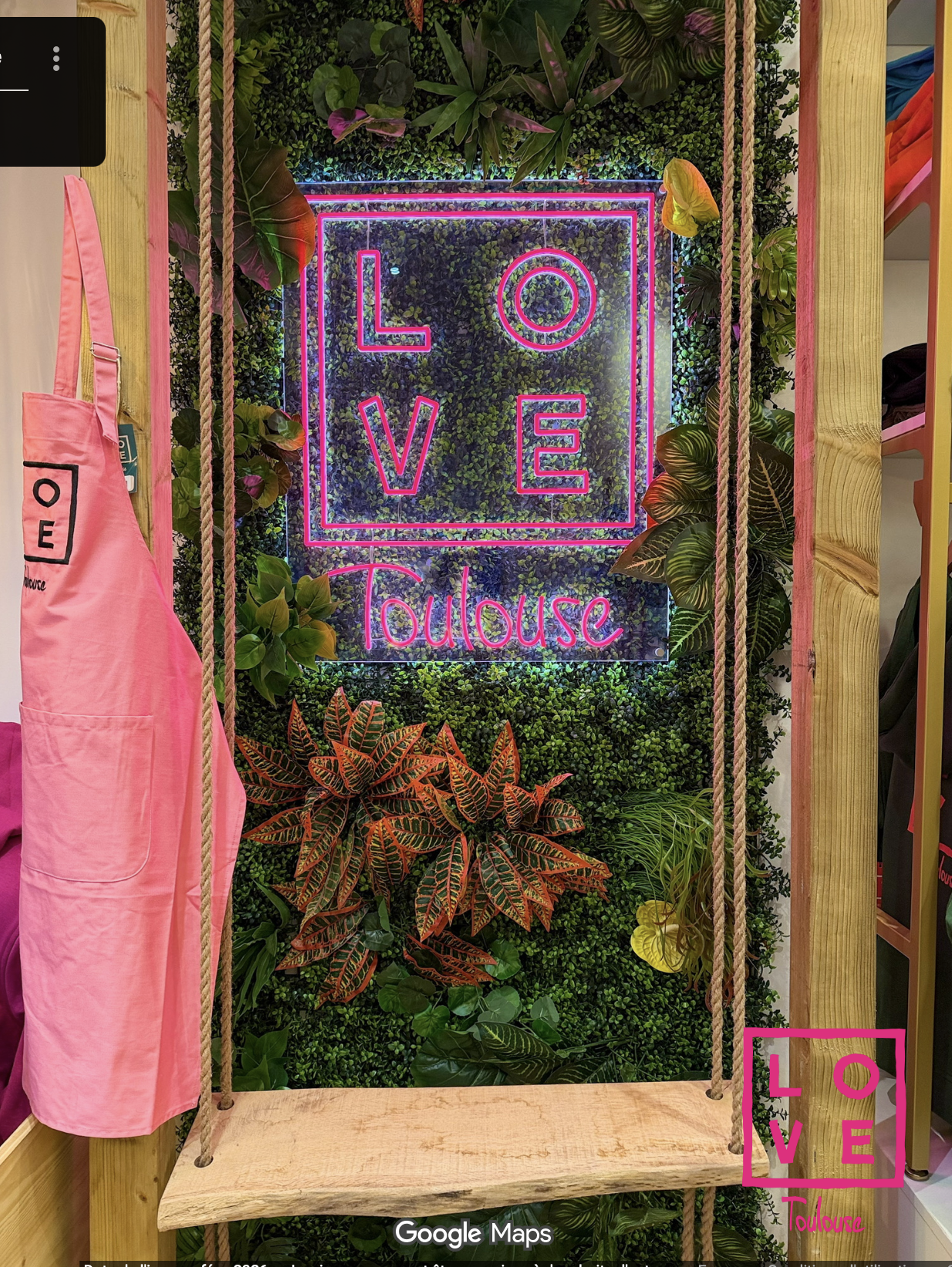 Mur végétal avec néon LOVE Toulouse rose — décor iconique de la boutique